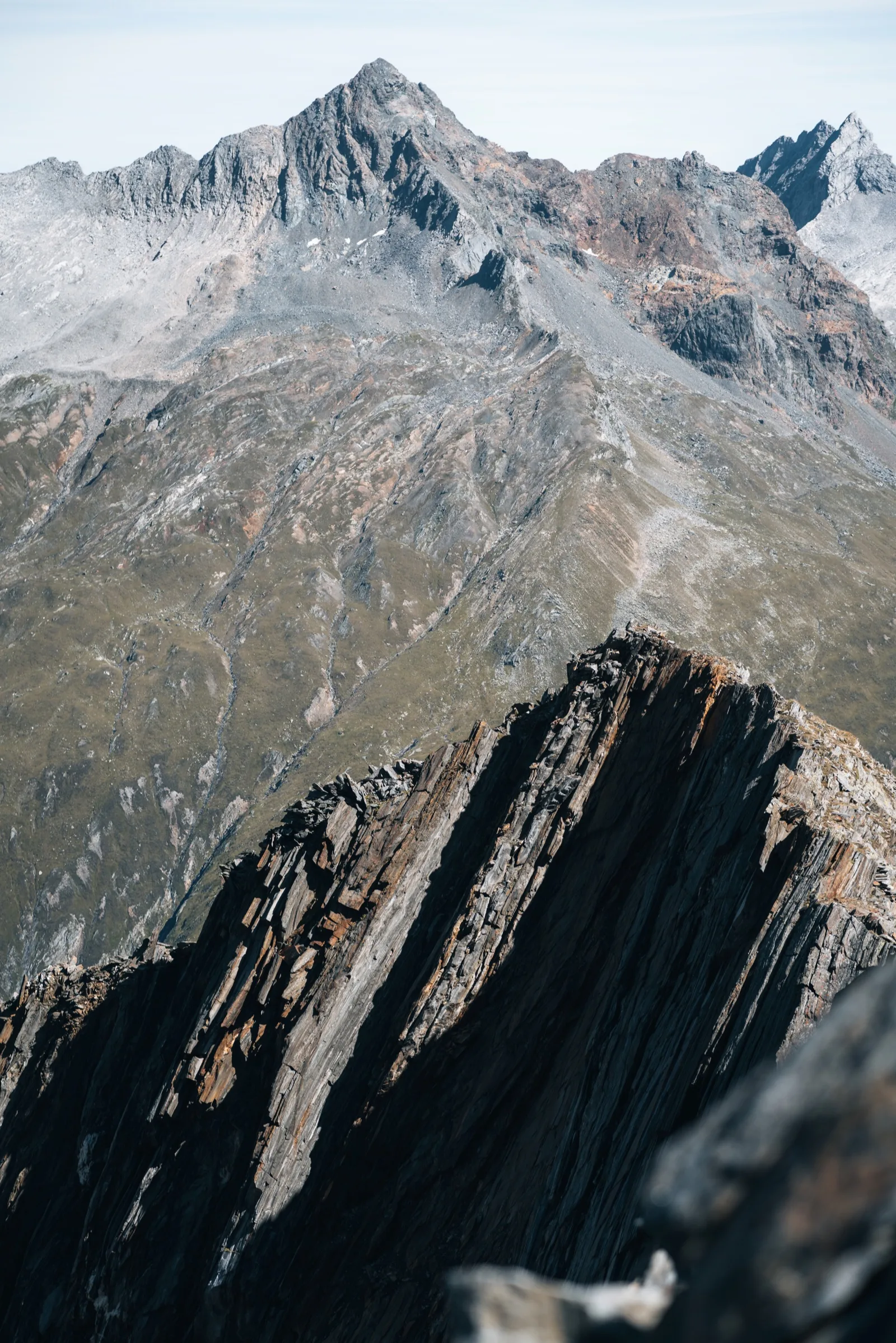 A rocky mountain ridge rising under a pale sky